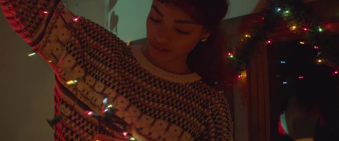 Woman unravels a string of lit christmas lights