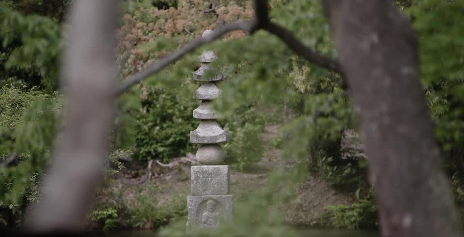 A small stone sculpture sits in the garden ahead