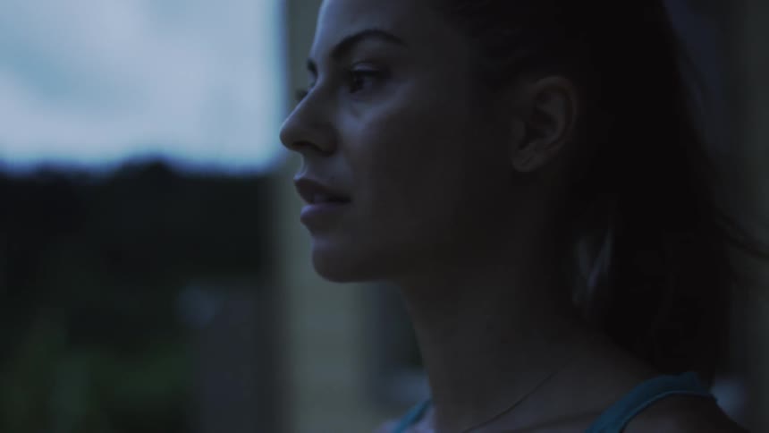 A woman looks forward at sunset