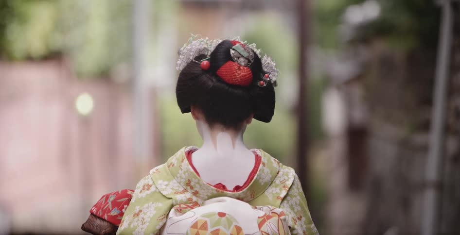 Woman in a kimono carries a package as she walks