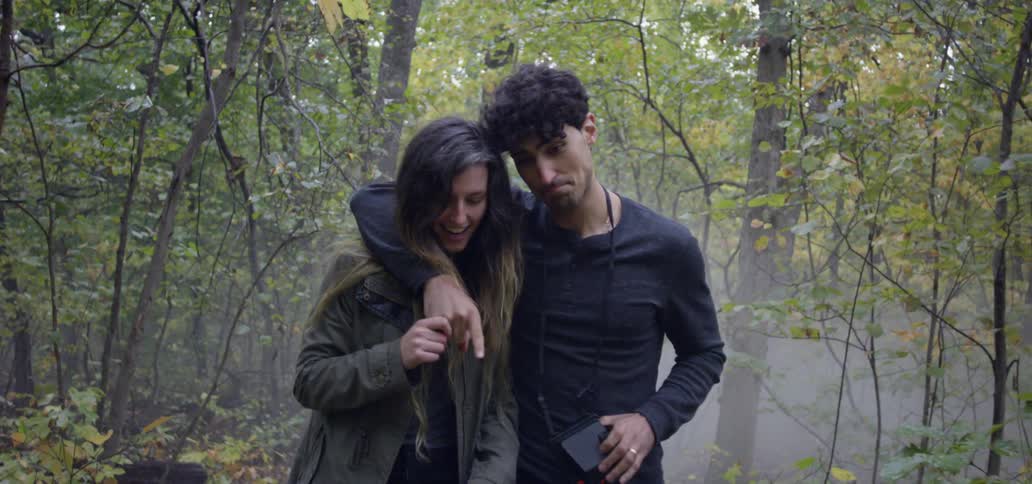 A man and woman hike in a forest
