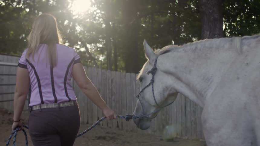 Woman leading her horse with a rope