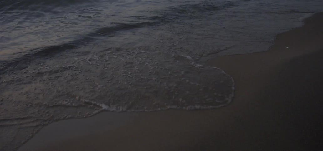 Water splashes to shore on a sandy beach