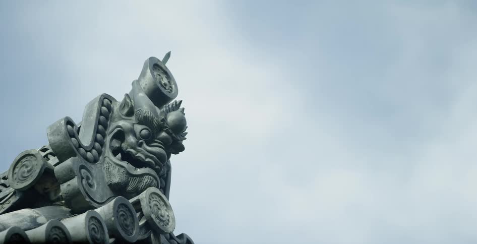 A snarling gargoyle on a building peak on a sunny day