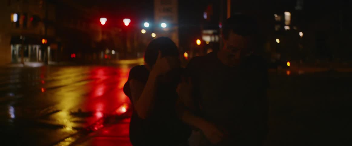 People walking on a sidewalk in a city at night