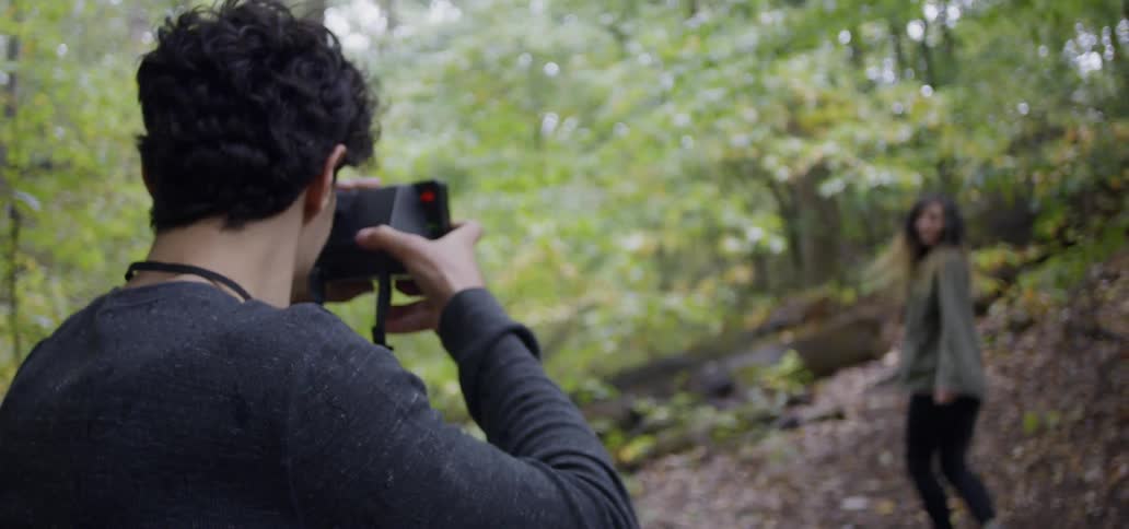 A man and woman hike in a forest
