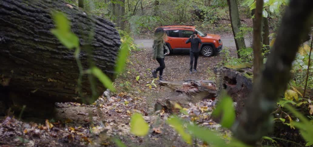 A man takes a photo of a woman as she walks up a trail