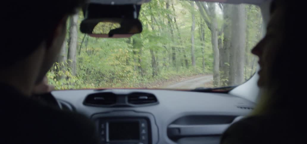 Man drives a vehicle with a woman through the forest