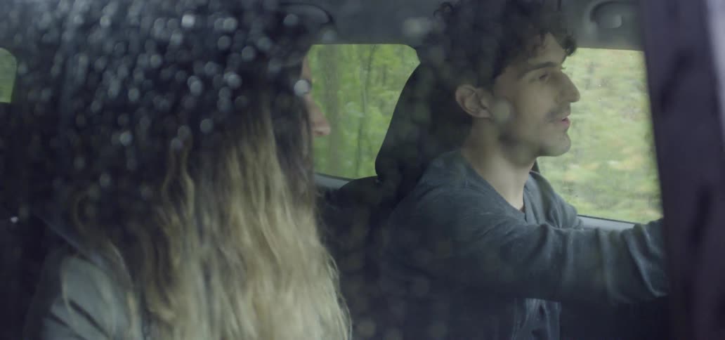 Woman laughs as she travels in a vehicle with a man