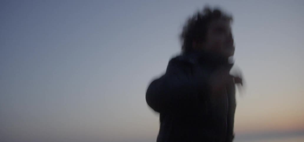 Boy runs on a beach at sunset