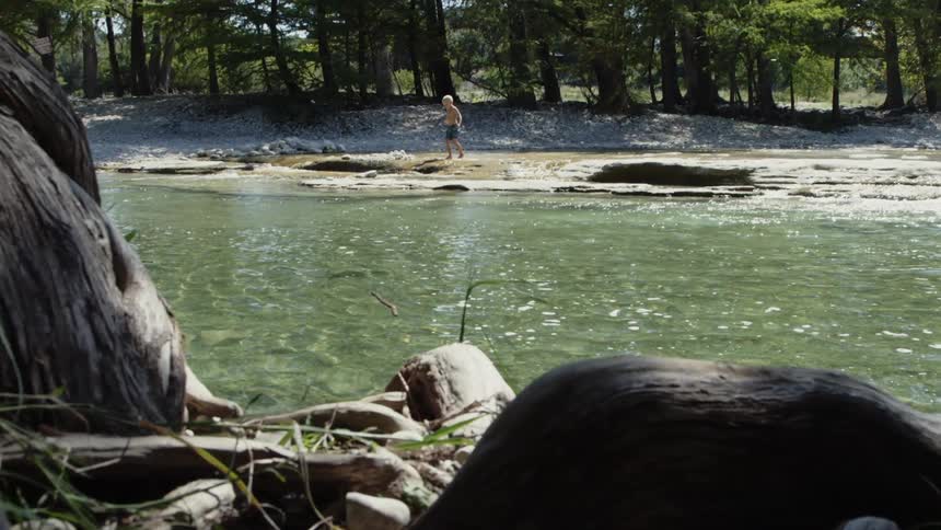 A man walks on the river bank
