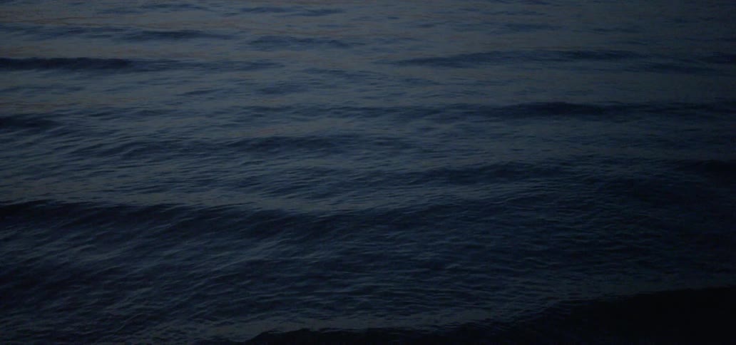 Small waves rippling in the ocean at night