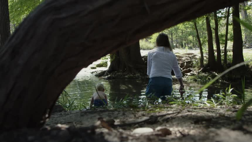 Woman and two children wade in a lake