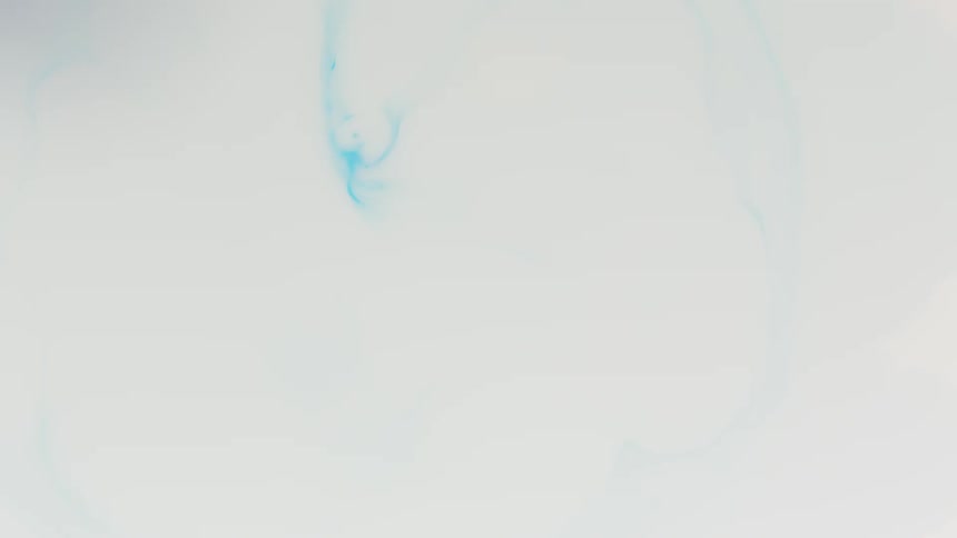 Blue liquid droplet splashes into white liquid