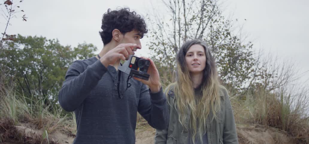The man takes a picture standing next to a woman