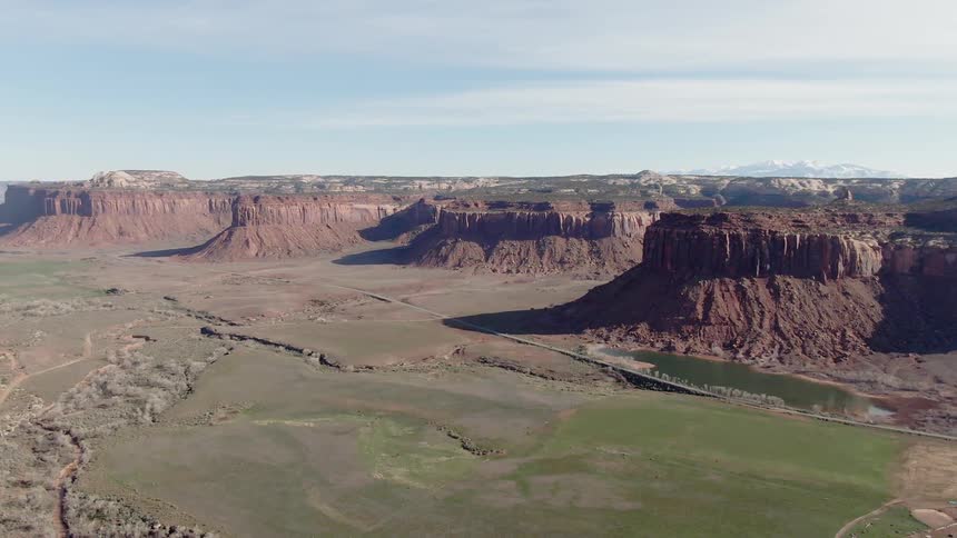 The green fields leads to the tall rocks