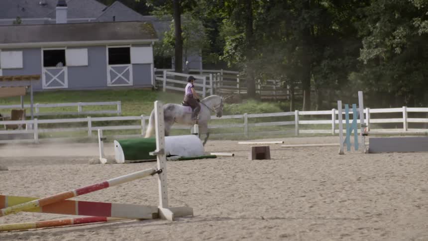 A woman riding a horse in a training paddock