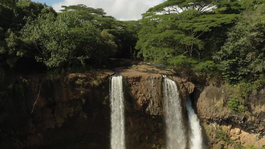 Water rushes from three spots on the cliff waterfall
