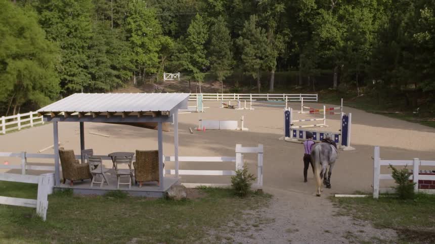 Man walking a horse in a corral