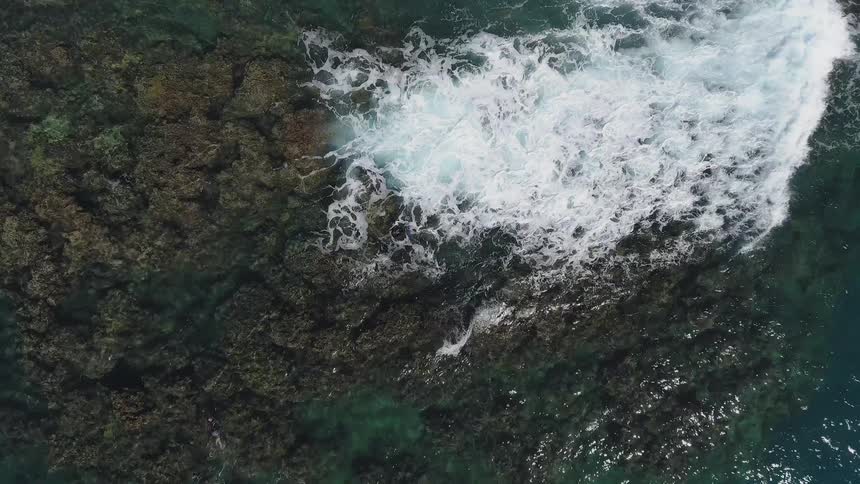 The water is rough splashing against the rocks