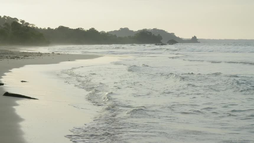 The waves slowly move on the sand of the shore