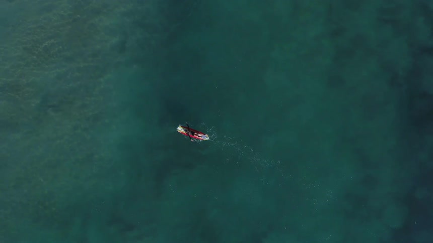 Person paddles a canoe in the ocean