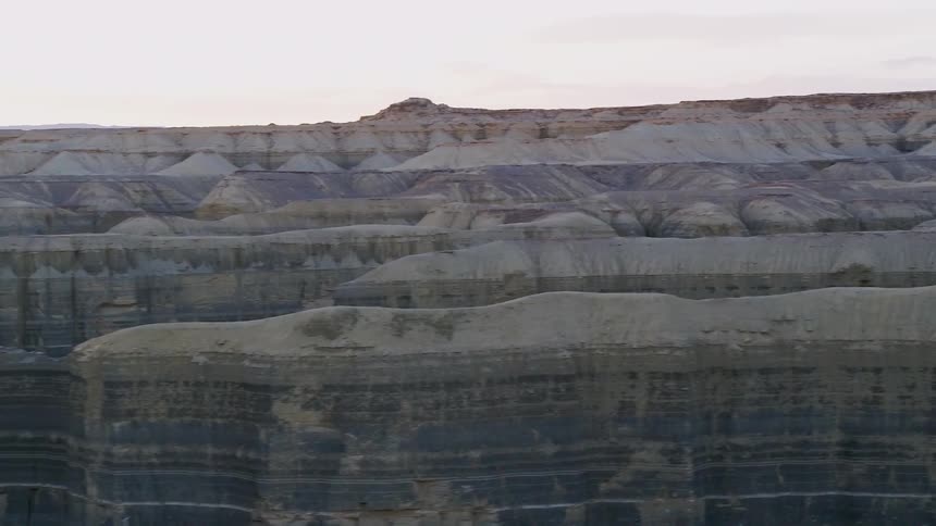 Flat hills sit in the desert under a cloudy sky