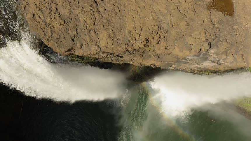 A waterfall flows over a cliff