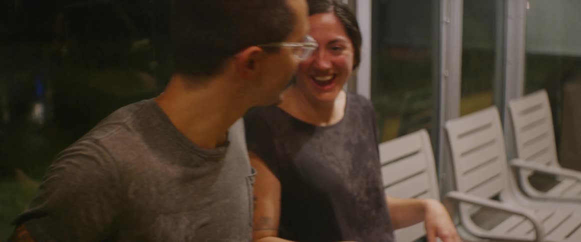 The people laugh as they sit at the bus stop