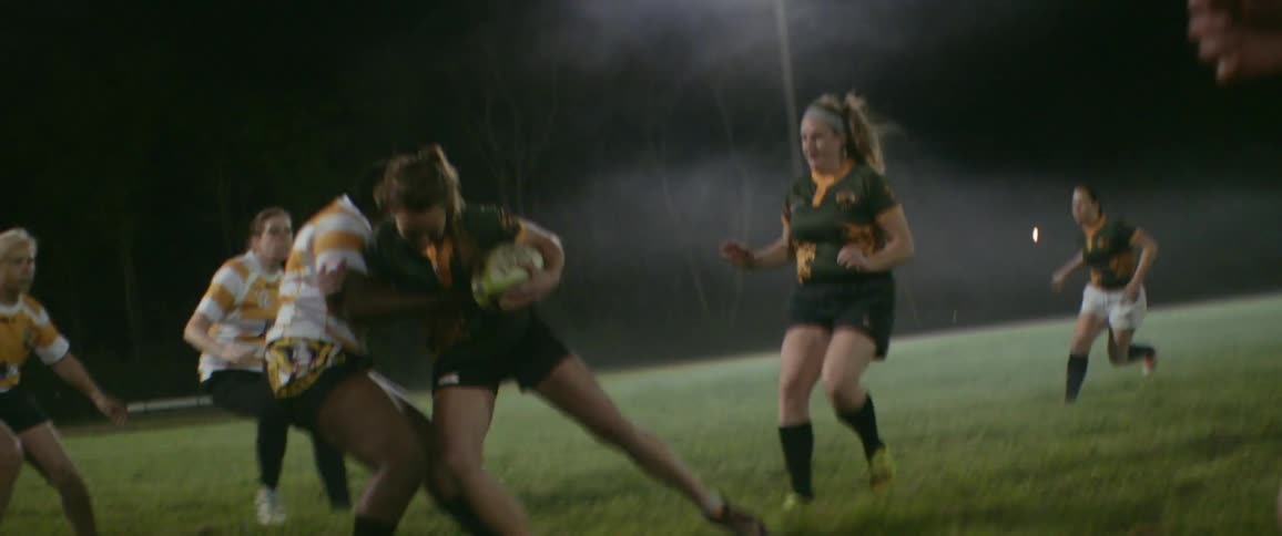 Girls are playing rugby at night