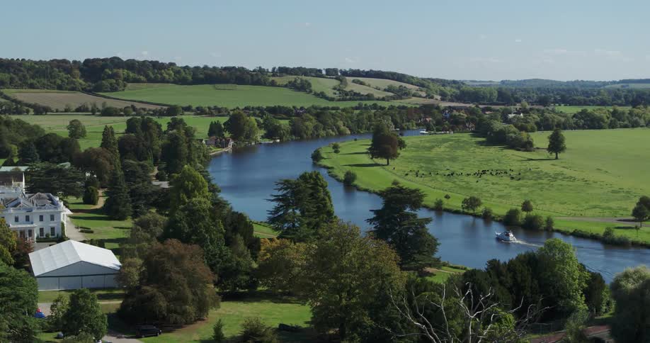 The river runs past these homes on the green field