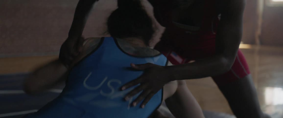 Two women wrestle in a gymnasium