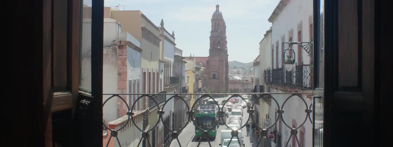 Balcony overlooking a busy city street on a sunny day
