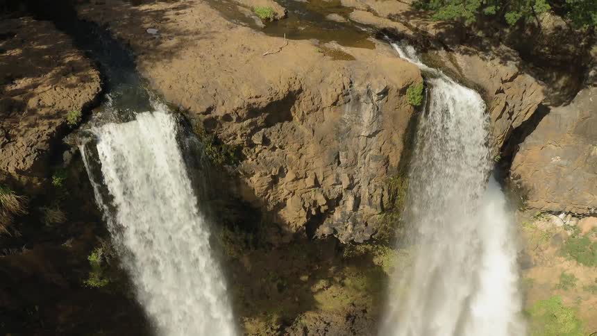 The two waterfalls create a small rainbow