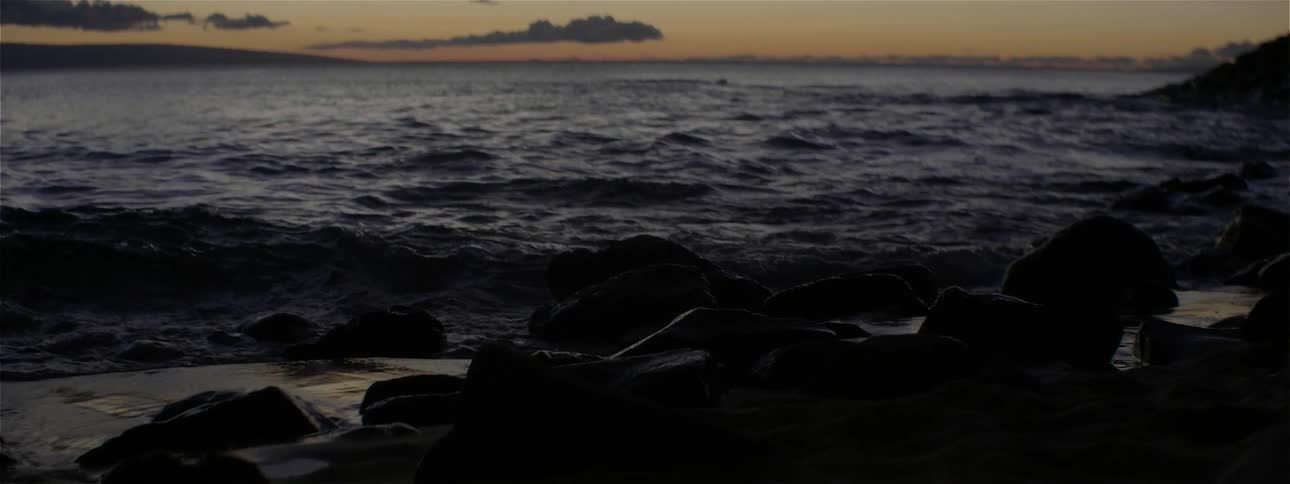 Ocean waves flow on a beach at sunset