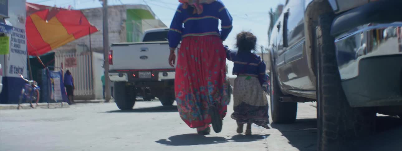 A woman and young girl walk on a city street