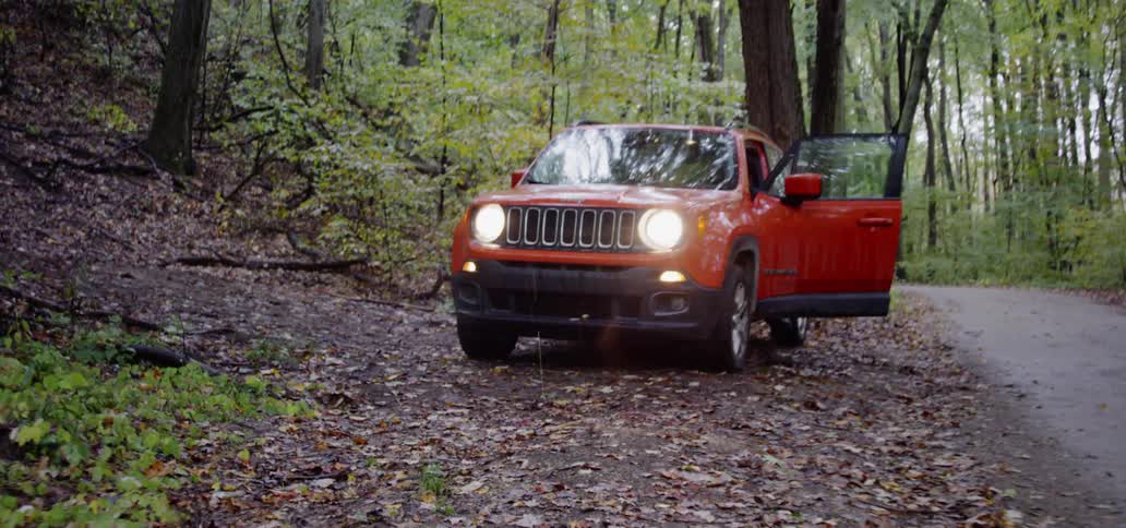 A couple runs to their car parked at the end of a trail in the woods