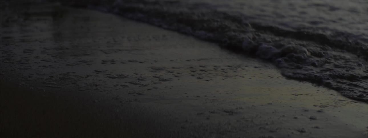 Water splashes onto sandy beach