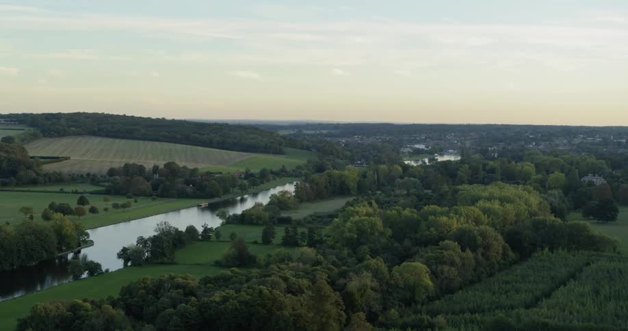 River flows through farmland at sunset
