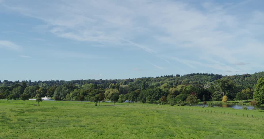 Green fields and trees lead to a canal