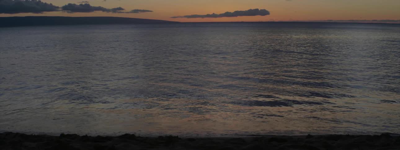 The water is rough and hitting the shore at dawn