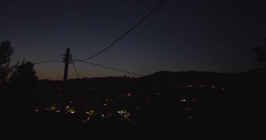 A city at night with trees and mountains