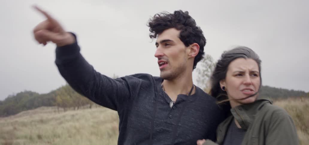 Man and woman hike on a windy day