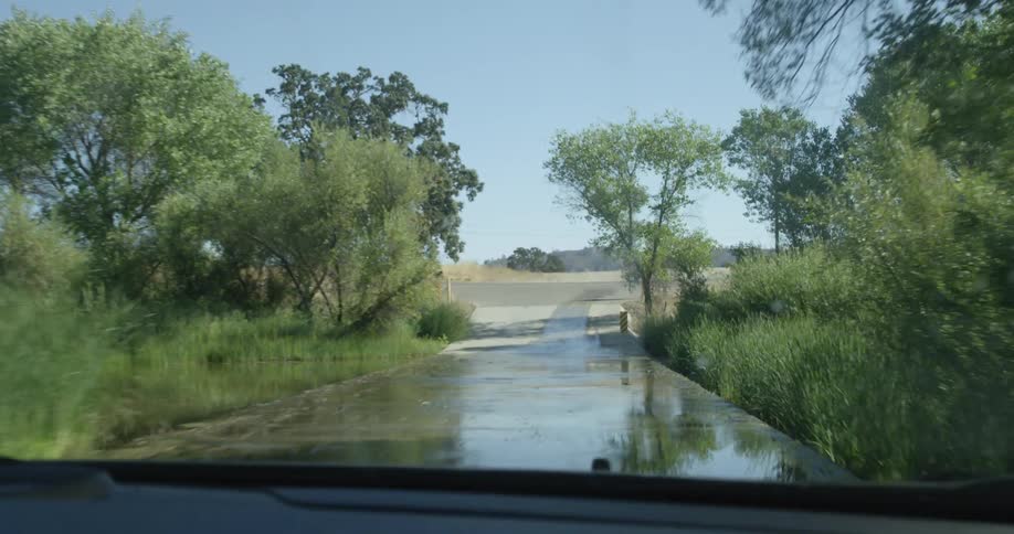 A vehicle drives on a rural road