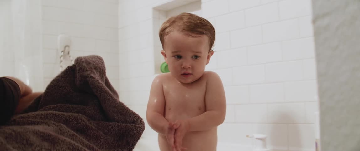 A woman bathes a young child in the tub
