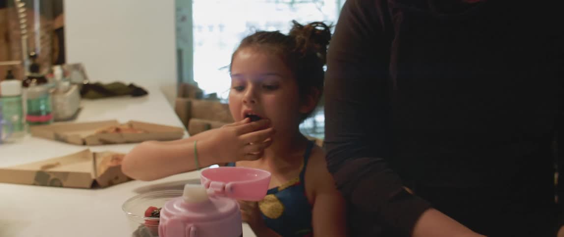 Woman and child eat at a kitchen table