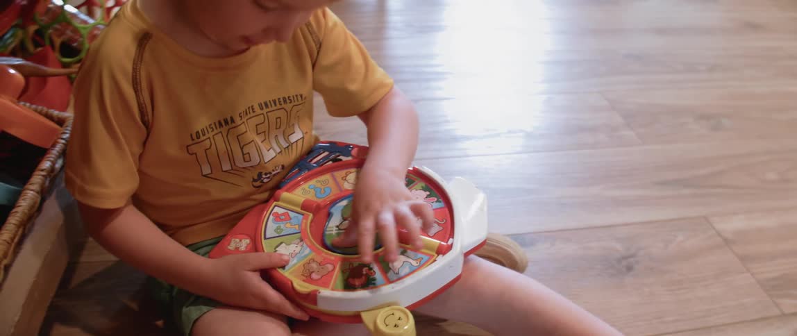 Child playing with a toy on a hardwood floor