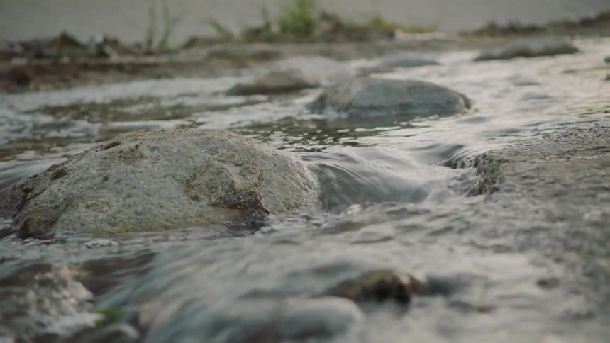Water flows between rocks down the stream