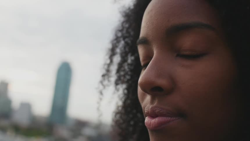 Woman standing outside closes her eyes