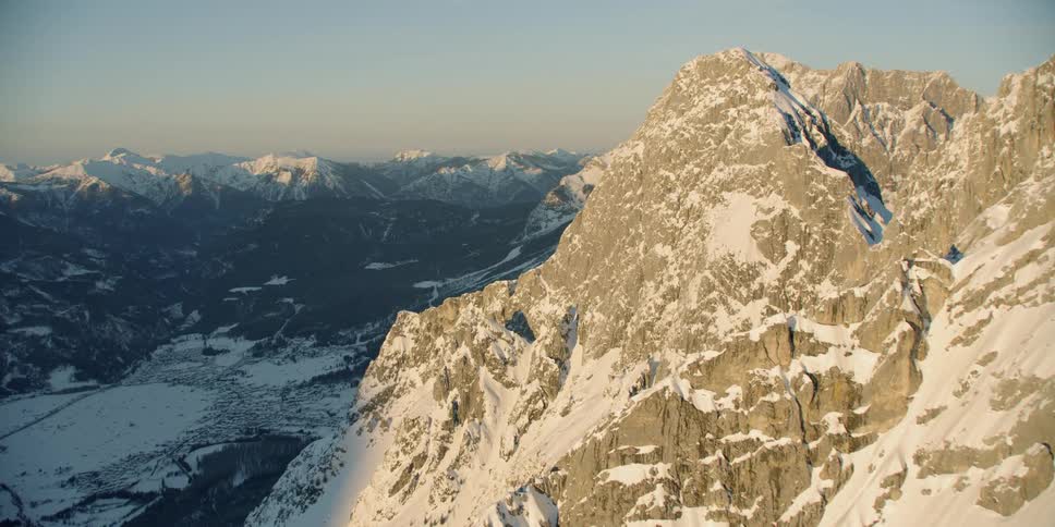 Snow covered mountains sit under a bright blue sky